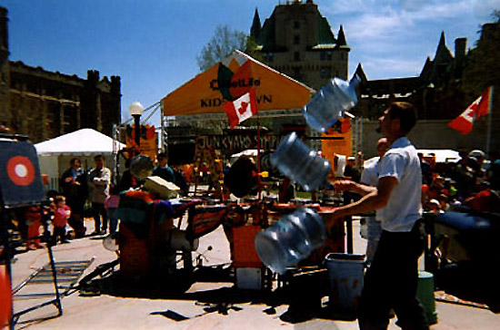 Junkyard Jonny juggling five-gallon water jugs!